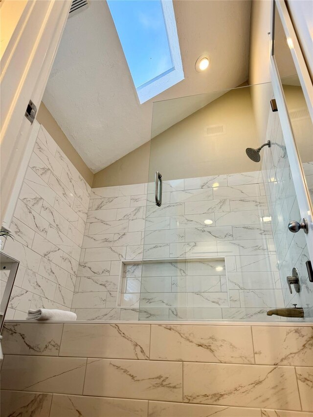 bathroom featuring walk in shower and vaulted ceiling with skylight