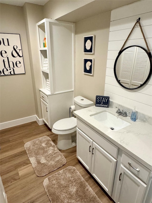 bathroom featuring wood-type flooring, vanity, and toilet