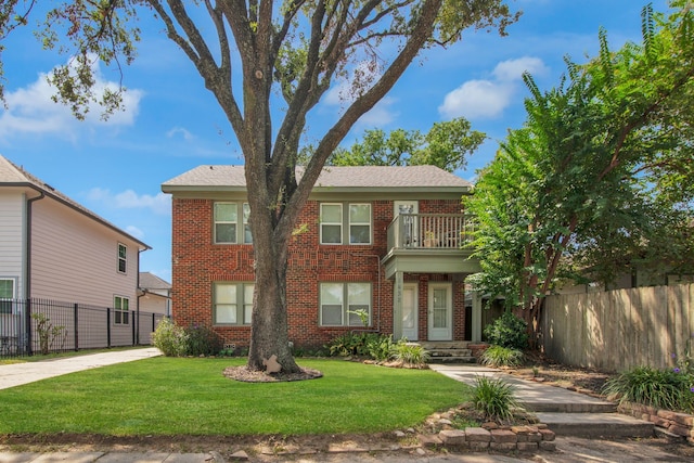 view of front of house featuring a balcony and a front lawn