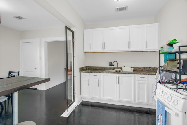 kitchen featuring dark stone counters, white cabinetry, and dark wood-type flooring