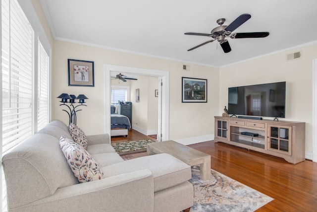 living room featuring ornamental molding, ceiling fan, and dark wood-type flooring