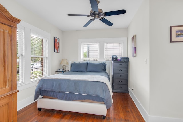 bedroom with ceiling fan, dark hardwood / wood-style flooring, and multiple windows