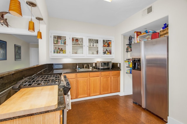 kitchen featuring pendant lighting, sink, white cabinetry, kitchen peninsula, and stainless steel appliances