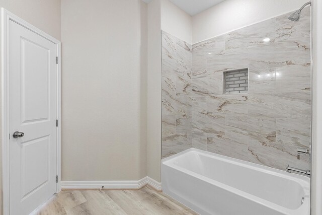 bathroom with hardwood / wood-style flooring and tiled shower / bath combo