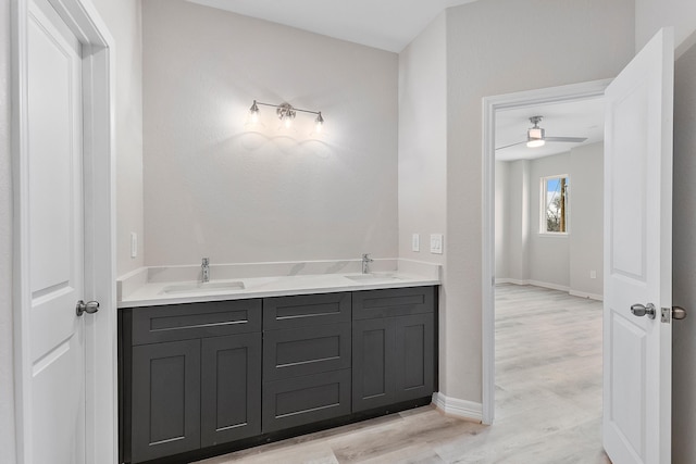 bathroom with ceiling fan, vanity, and wood-type flooring