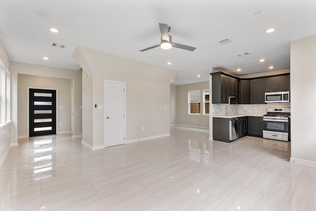 kitchen with dark brown cabinetry, sink, tasteful backsplash, ceiling fan, and stainless steel appliances