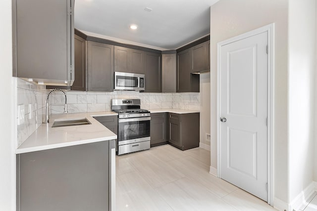 kitchen with tasteful backsplash, appliances with stainless steel finishes, sink, and dark brown cabinets