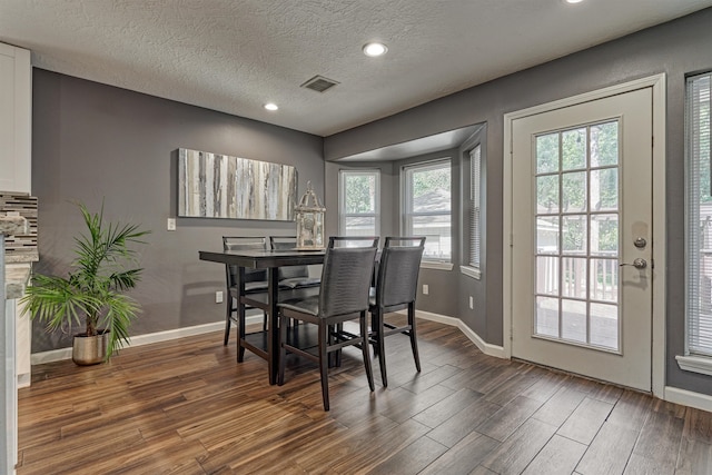 dining area featuring a textured ceiling and dark hardwood / wood-style floors