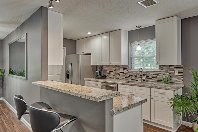 kitchen with white cabinets, a kitchen bar, dark hardwood / wood-style floors, and sink