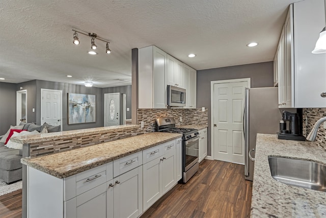 kitchen featuring dark hardwood / wood-style flooring, white cabinets, appliances with stainless steel finishes, and sink