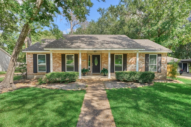 ranch-style house featuring covered porch and a front yard