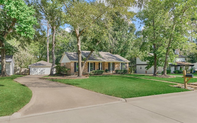 single story home featuring covered porch, a front yard, and an outbuilding