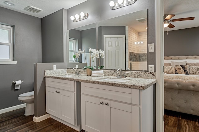 bathroom featuring wood-type flooring, ceiling fan, vanity, and toilet