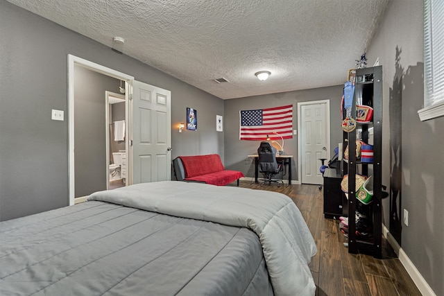 bedroom featuring a textured ceiling and dark hardwood / wood-style floors