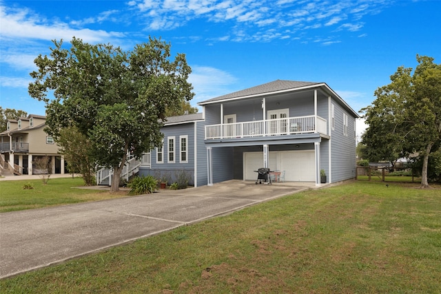 view of front of property featuring a garage, a balcony, and a front lawn