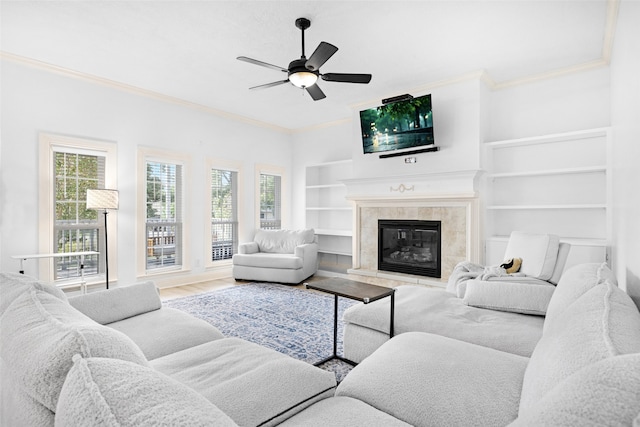 living room with a fireplace, wood-type flooring, ceiling fan, and a healthy amount of sunlight