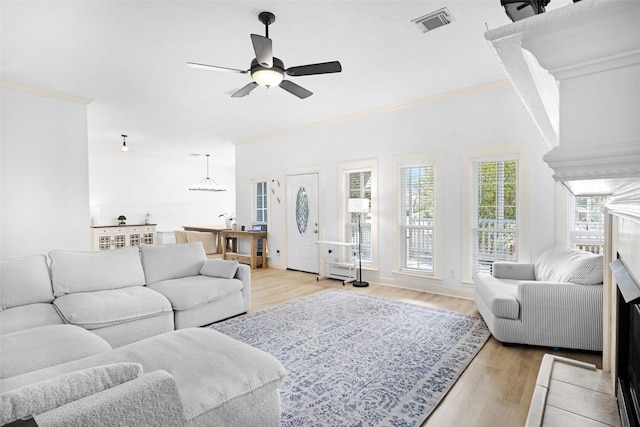 living room featuring light wood-type flooring, ceiling fan, and crown molding