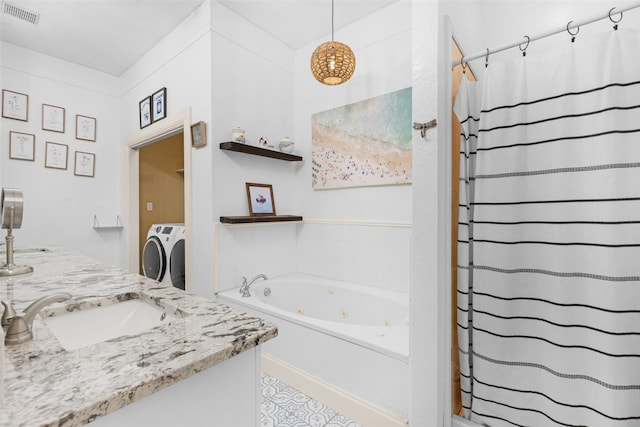 bathroom featuring washing machine and dryer, plus walk in shower, and vanity