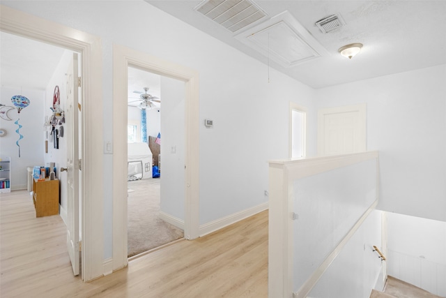 corridor with light hardwood / wood-style floors