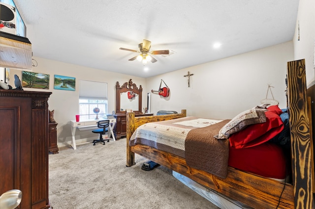 carpeted bedroom featuring ceiling fan and a textured ceiling