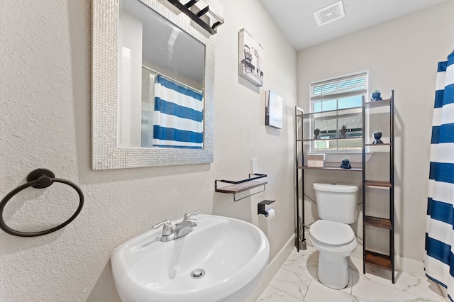 bathroom with sink, toilet, and curtained shower