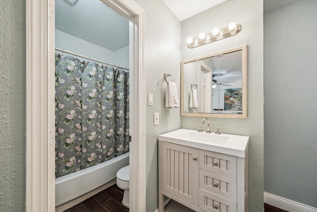 full bathroom with a textured ceiling, shower / bathtub combination with curtain, wood-type flooring, toilet, and vanity