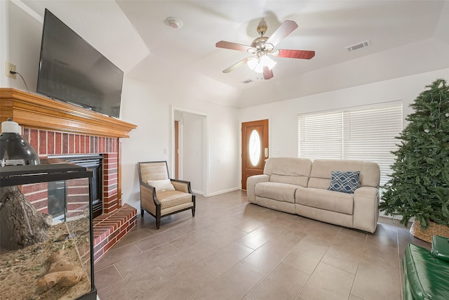 tiled living room featuring ceiling fan and a fireplace