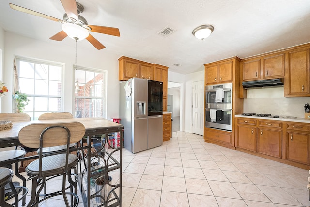 kitchen with ceiling fan, stainless steel appliances, light tile patterned floors, and tasteful backsplash