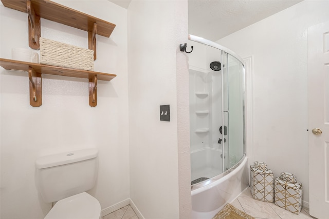 bathroom featuring enclosed tub / shower combo, tile patterned flooring, and toilet