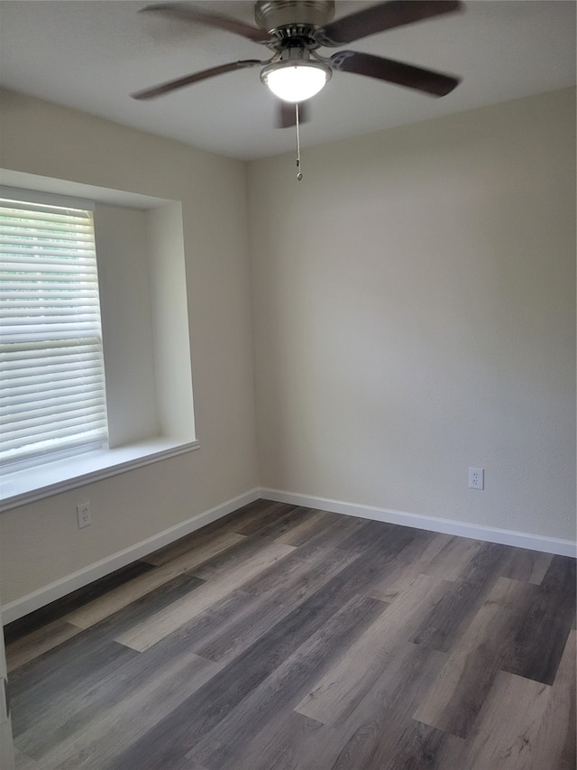 spare room with dark wood-type flooring and ceiling fan