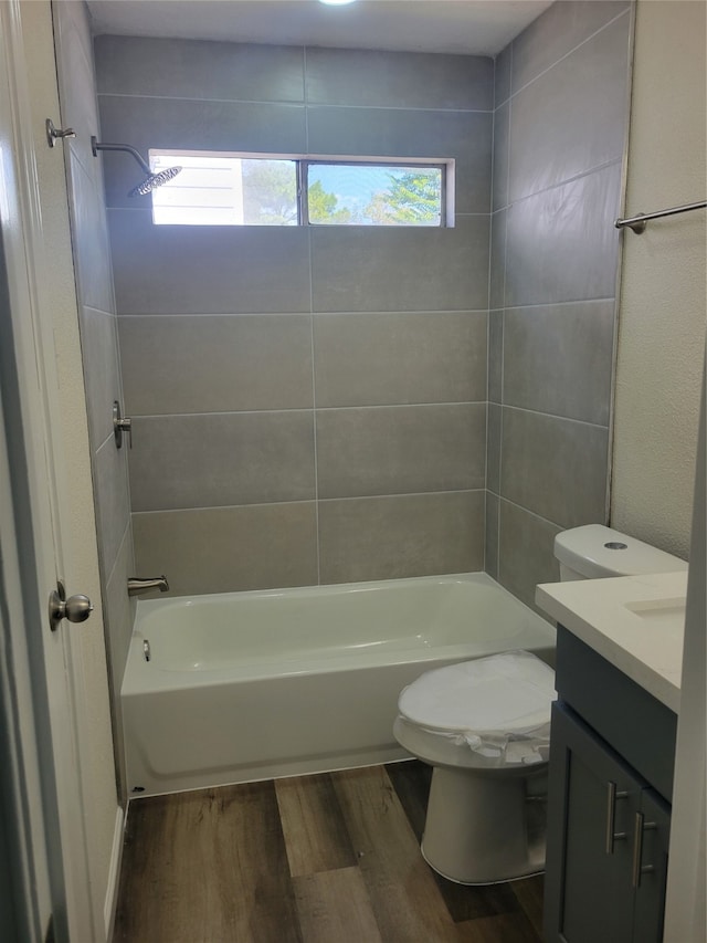 full bathroom featuring wood-type flooring, a wealth of natural light, vanity, and toilet