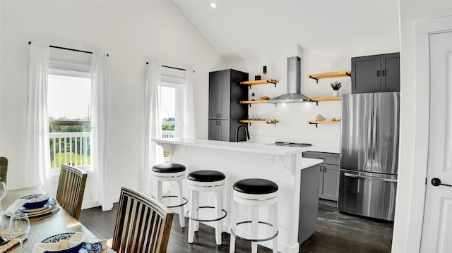 kitchen featuring a kitchen breakfast bar, gray cabinets, stainless steel appliances, island exhaust hood, and lofted ceiling