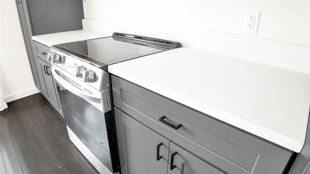 kitchen featuring electric stove, gray cabinets, and dark wood-type flooring