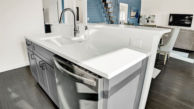 kitchen featuring sink, gray cabinetry, stainless steel dishwasher, a kitchen island with sink, and dark hardwood / wood-style floors