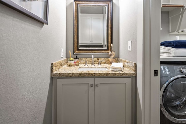 bathroom with vanity and washer / dryer