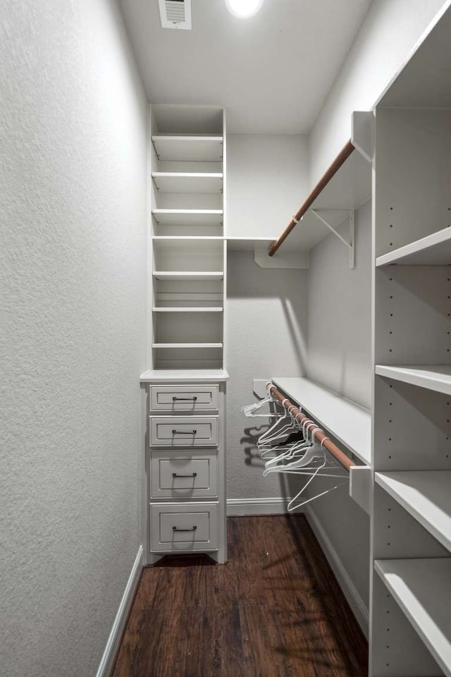 spacious closet featuring dark hardwood / wood-style floors