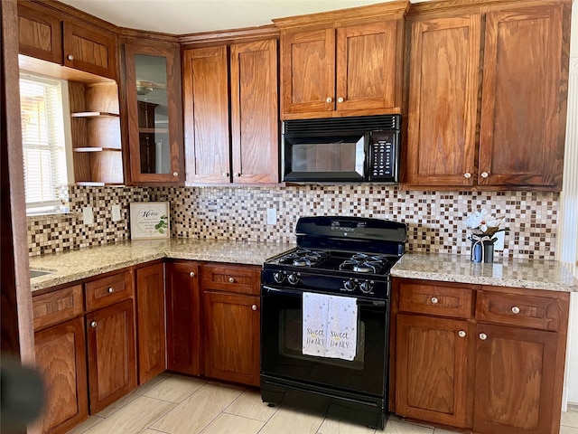 kitchen with light stone counters, backsplash, and black appliances