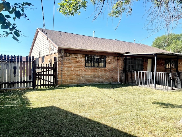 exterior space with a lawn, brick siding, and fence