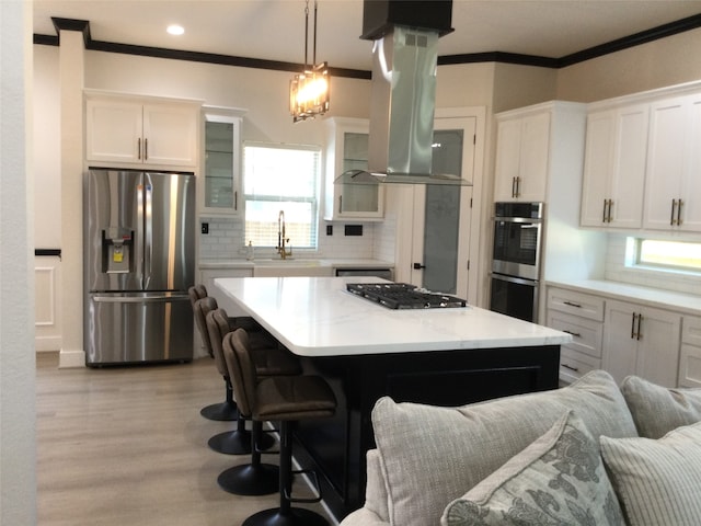 kitchen featuring stainless steel appliances, white cabinets, hanging light fixtures, and a kitchen island