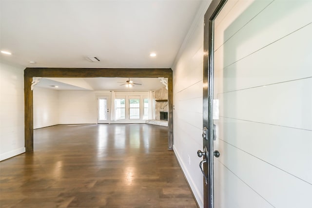 empty room featuring beam ceiling, dark hardwood / wood-style floors, and ceiling fan