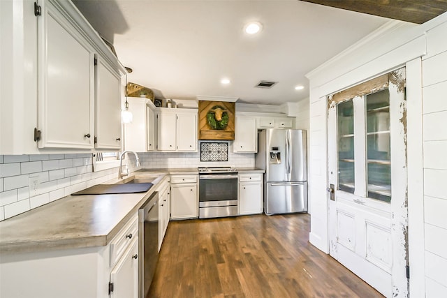 kitchen with white cabinets, sink, decorative light fixtures, appliances with stainless steel finishes, and dark hardwood / wood-style floors