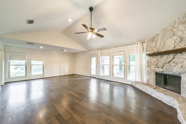 unfurnished living room with a wealth of natural light, dark wood-type flooring, ceiling fan, and a fireplace