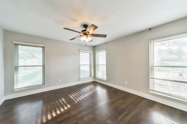 unfurnished room featuring ceiling fan, plenty of natural light, and dark wood-type flooring