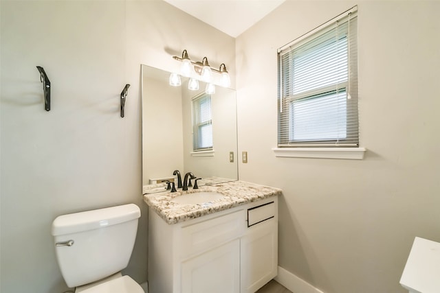 bathroom featuring vanity, toilet, and a wealth of natural light