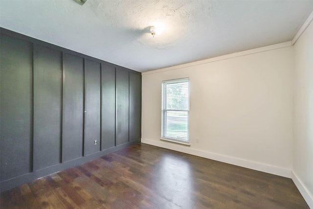 unfurnished room featuring a textured ceiling and dark hardwood / wood-style flooring