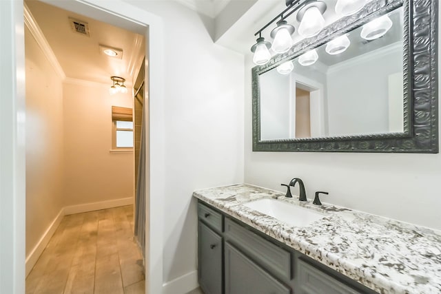 bathroom with hardwood / wood-style flooring, vanity, and crown molding