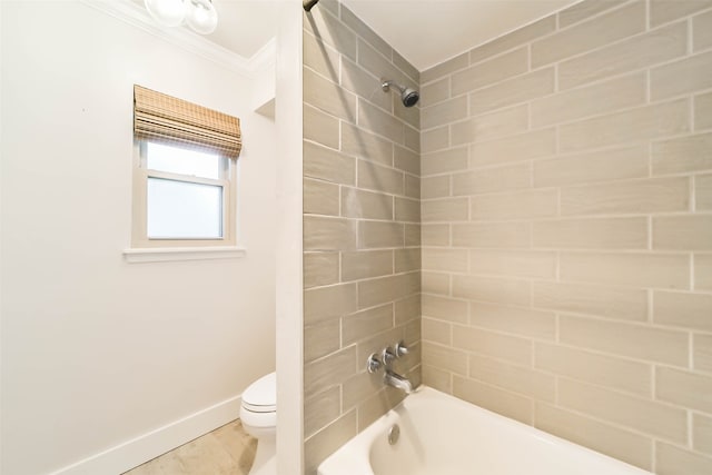 bathroom with tiled shower / bath combo, toilet, and crown molding