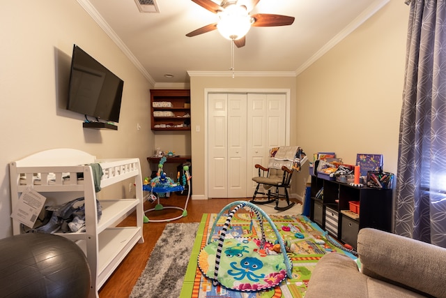 game room with ornamental molding, ceiling fan, and dark hardwood / wood-style floors