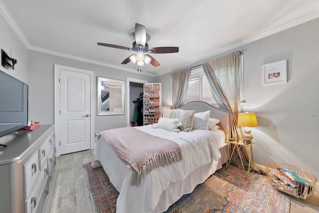 bedroom with ornamental molding, hardwood / wood-style flooring, and ceiling fan