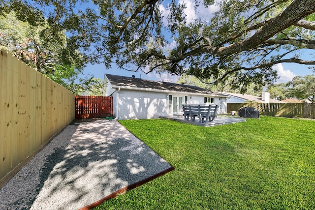 back of house with a patio area and a yard